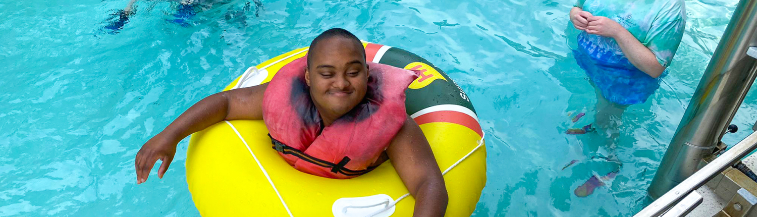 Easterseals UCP camper swimming in pool with float