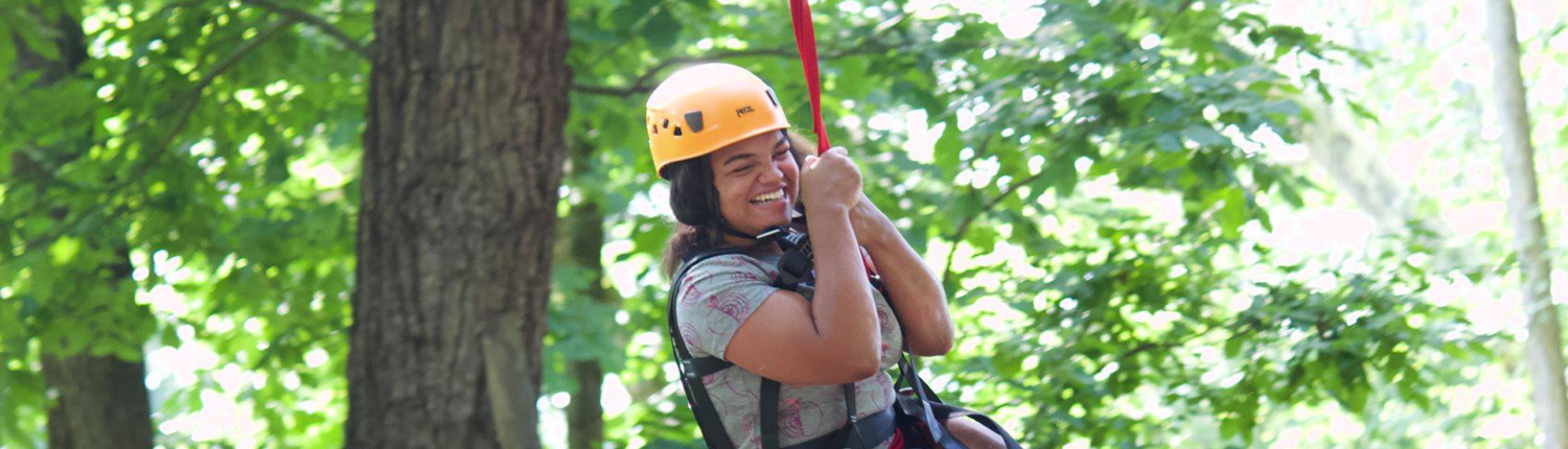 Easterseals UCP camper smiling on rope swing