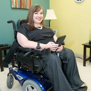 Woman in wheelchair using assistive technology