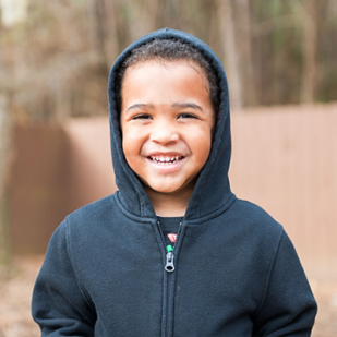 Young Child First NC client smiling with hoodie on