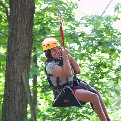 Camp easterseals UCP camper on rope swing smiling